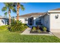 House front with walkway, landscaping, and palm trees at 10306 Chatuge Dr, San Antonio, FL 33576