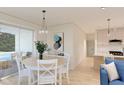 Bright dining area with white table and chairs, kitchen view, and access to patio at 1712 W Arch St, Tampa, FL 33607