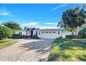 White two-story house with a three-car garage, palm trees and landscaped yard at 105 Estado Ne Way, St Petersburg, FL 33704