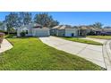 Single-story home with gray exterior, attached garage, and a spacious driveway at 16700 Caracara Ct, Spring Hill, FL 34610