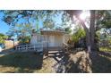 Front view of a light tan house with a white ramp and mature trees at 1708 Preston S St, St Petersburg, FL 33712