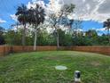 Large backyard with a wooden fence, providing privacy and ample space at 5714 Olive Dr, New Port Richey, FL 34652