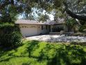 Single-story house with attached garage and manicured lawn at 1291 S Disston Ave, Tarpon Springs, FL 34689