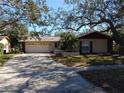 Single-story house with attached two-car garage and driveway at 1291 S Disston Ave, Tarpon Springs, FL 34689