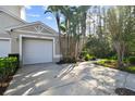 Two-car garage with driveway and lush landscaping at 1687 Starling Drive, Tarpon Springs, FL 34689
