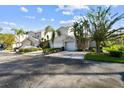 Townhouse exterior with driveway, landscaping, and two-car garage at 1687 Starling Drive, Tarpon Springs, FL 34689