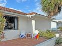 Relaxing patio with two white chairs, side table, and colorful beach towels at 2460 W Marion Ave, Punta Gorda, FL 33950