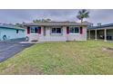 One-story home with maroon shutters and a manicured lawn at 3505 Casablanca Ave, St Pete Beach, FL 33706