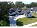 Modern white house with gray roof and a two-car garage, nicely landscaped at 4675 Hickory Oak Dr, Brooksville, FL 34601