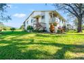 Charming exterior of home with lush front lawn, mature tree, and vibrant landscaping at 8019 Feather Ct # C, Hudson, FL 34667