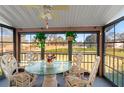 Screened porch with glass-top table and chairs, overlooking yard at 8019 Feather Ct # C, Hudson, FL 34667
