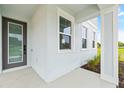 Modern front entry with gray door and columns at 2021 Amelia Bay Pl, Valrico, FL 33596