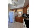 Kitchen with white appliances and view to living area at 4660 Marine Pkwy # 202, New Port Richey, FL 34652