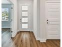 Inviting hallway with wood flooring, a modern front door and adjacent closet at 5825 S 5Th St, Tampa, FL 33611