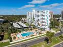 Condominium building with a beautiful pool, parking, and lush landscaping on a sunny day at 2401 Bayshore Blvd # 410 & 510, Tampa, FL 33629