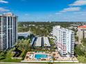 Wide view of two condos, a parking lot, and a pool surrounded by trees, under a bright sky at 2401 Bayshore Blvd # 410 & 510, Tampa, FL 33629