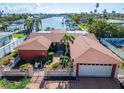 Waterfront home with red roof and two-car garage at 425 Capri Blvd, Treasure Island, FL 33706
