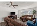 Living room with brown sofas, a TV, and wood-look floors at 7075 Lafayette N, Pinellas Park, FL 33781