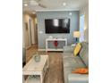 Living room features a large TV, gray leather sofa, and a console table at 919 50Th W Ave, Bradenton, FL 34207