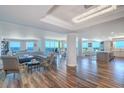 Elegant open-concept living space with wood floors, modern lighting, and panoramic ocean views from the large windows at 800 Collany Rd # 605 & 606, Tierra Verde, FL 33715