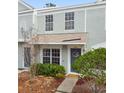 Light-blue townhouse with a welcoming front door, complemented by manicured landscaping at 2345 Lake Woodberry Cir, Brandon, FL 33510