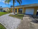 Yellow house exterior, palm tree, white rock pathway, and attached garage at 3141 Ludlow Dr, New Port Richey, FL 34655