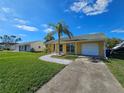House exterior showcasing a yellow home with a palm tree and landscaped yard at 3141 Ludlow Dr, New Port Richey, FL 34655