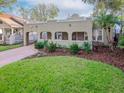 Spanish style home with landscaped yard and brick driveway at 3512 W Granada St, Tampa, FL 33629