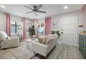Bright living room with white sofa, pink accents, and ceiling fan at 946 23Rd S Ave, St Petersburg, FL 33705