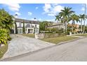 House with a paved driveway, landscaping, and palm trees at 140 Brightwaters Ne Blvd, St Petersburg, FL 33704