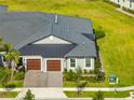 Two-car garage, gray house, gray roof, paved driveway at 31500 Magna Gulf Loop, San Antonio, FL 33576