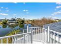 Expansive balcony view overlooking a serene lake, surrounding trees, and neighborhood homes at 3295 Hibiscus Dr, Hernando Beach, FL 34607