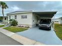 Front view of a manufactured home with carport and landscaping at 34185 Canal N Dr, Pinellas Park, FL 33781