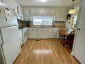 Bright kitchen with white cabinets, laminate floor, and breakfast nook at 34185 Canal N Dr, Pinellas Park, FL 33781