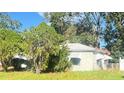 One-story stucco home with mature landscaping and a damaged awning at 3907 W Walnut St, Tampa, FL 33607