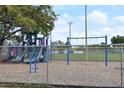 Community playground featuring slides and swings, with a fence ensuring safety in a well-maintained environment at 446 Rotary Ne Pl, St Petersburg, FL 33703