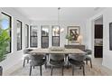 Modern dining room with a large table, chandelier, and gray chairs at 741 58Th Ne Ave, St Petersburg, FL 33703