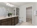 Double vanity bathroom with dark brown cabinets, a walk-in shower, and linen closet at 10533 Hidden Banks Gln, Parrish, FL 34219