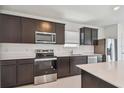 Well-equipped kitchen with stainless steel appliances, dark wood cabinets, and sleek countertops, creating a stylish cooking space at 10533 Hidden Banks Gln, Parrish, FL 34219