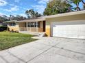 Single Gathering home with an attached garage, green lawn, and inviting front porch at 1182 Norwood Ave, Clearwater, FL 33756