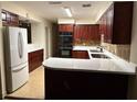 Well-lit kitchen featuring cherry wood cabinets, stainless steel appliances, and quartz countertops at 1182 Norwood Ave, Clearwater, FL 33756