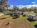 Sprawling yard with lush landscaping, multiple storage buildings and serene gazebo; idyllic backyard retreat at 11945 Carmen Ave, Dade City, FL 33525