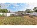 Fenced backyard with grassy lawn, white vinyl fence, and exterior view of the home at 1593 76Th N Ave, St Petersburg, FL 33702