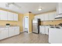 Traditional kitchen featuring white cabinetry, stainless steel refrigerator, and tiled floors at 1593 76Th N Ave, St Petersburg, FL 33702