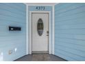 White front door with a glass oval window, light blue siding at 4373 Trout Se Dr, St Petersburg, FL 33705