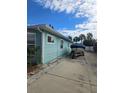 Side view of a light blue home with a boat parked on a concrete pad at 610 78Th Ave, St Pete Beach, FL 33706
