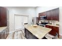 Modern kitchen with stainless steel appliances, wooden island, and lots of counter space at 10543 Opus Dr, Riverview, FL 33579