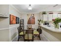 Cozy kitchen dining area with a round glass table and four chairs, featuring artwork and decor at 14816 Par Club Cir # 14816, Tampa, FL 33618