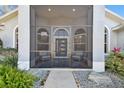 Screened porch with seating area at the front entrance at 1903 Gulf Beach Blvd, Tarpon Springs, FL 34689