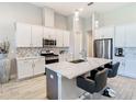 A modern kitchen featuring white cabinets, a quartz countertop island, and stainless steel appliances at 3901 Tour Trce, Land O Lakes, FL 34638